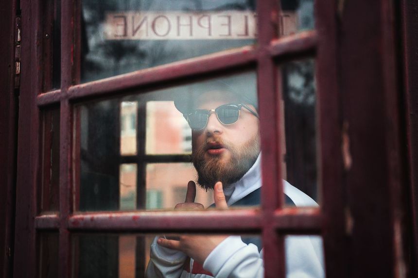 A man follows up after his interview inside a telephone booth