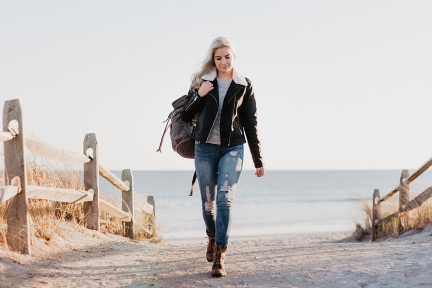 A woman carrying a backpack while walking towards new career opportunities because of layoffs