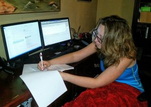 Woman rewriting her copy editor resume while working