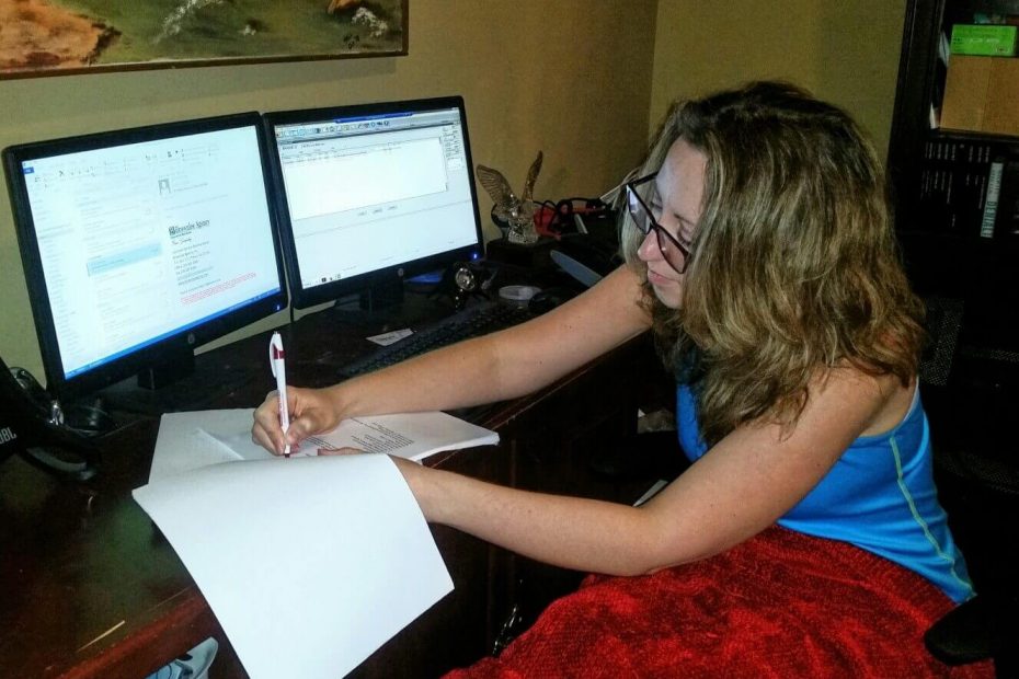Woman rewriting her copy editor resume while working