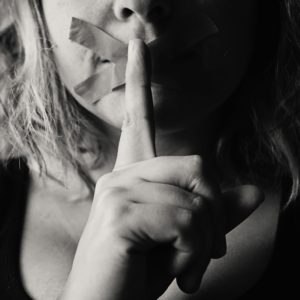 grayscale image of woman resume writer silencing to keep secrets to keyword optimization