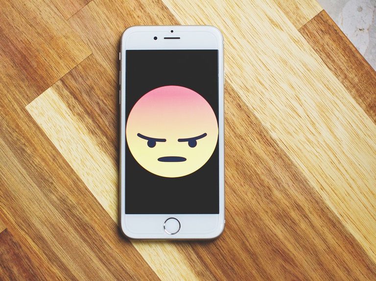 angry emoticon in a smartphone because of ripoff reviews
