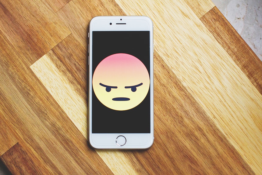 angry emoticon in a smartphone because of ripoff reviews