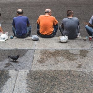 Five mean seated on the pavement depicting the search for in demand jobs