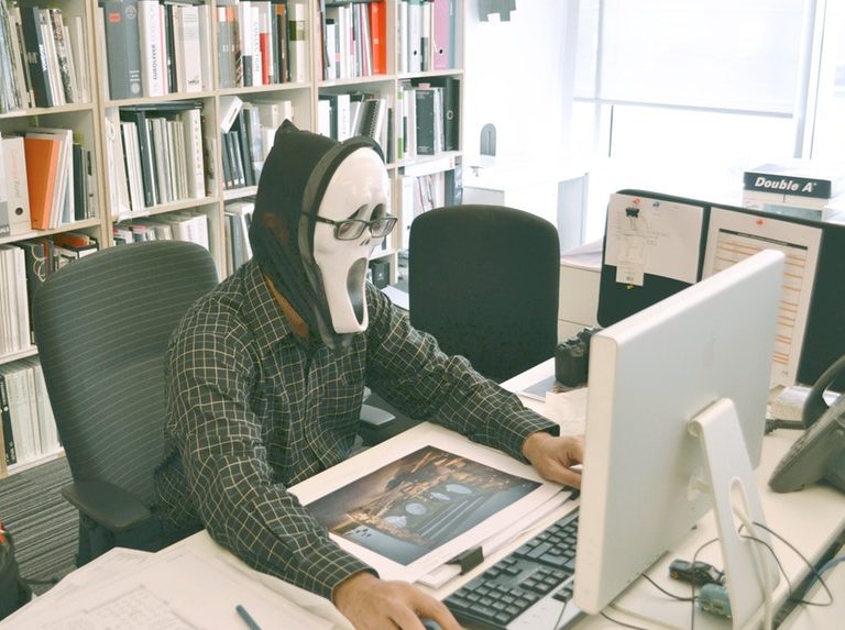 man wearing a mask in front of a computer hiding resume writing truths
