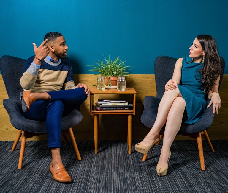 A man and woman sitting while discussing about career advice for millennials