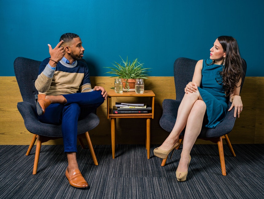 A man and woman sitting while discussing about career advice for millennials