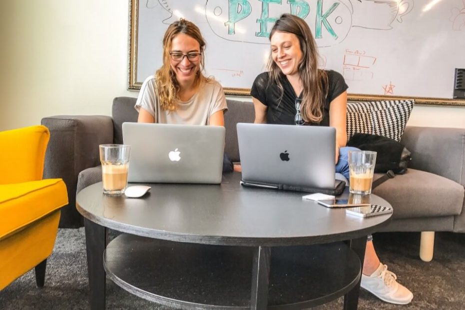 Two ladies looking for online job search tools using their macbook
