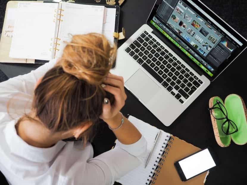 Woman thinking of her heavy workload and how to manage it