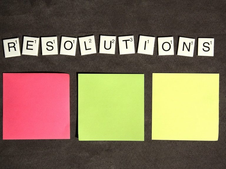 Three sticky notes and scrabble tiles to show listing of career resolutions