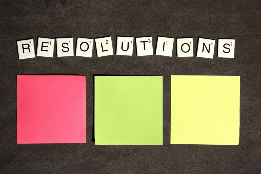 Three sticky notes and scrabble tiles to show listing of career resolutions