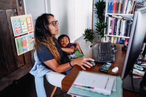 Young mom with sleeping kid looking for mom jobs online