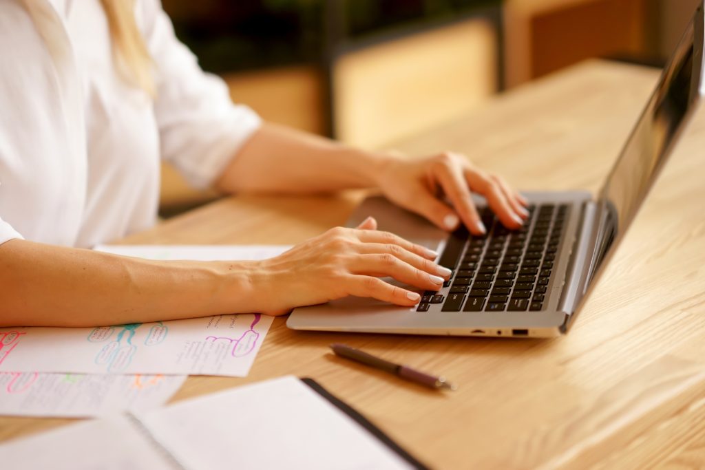 a job applicant woman working on her laptop to create a job portfolio 