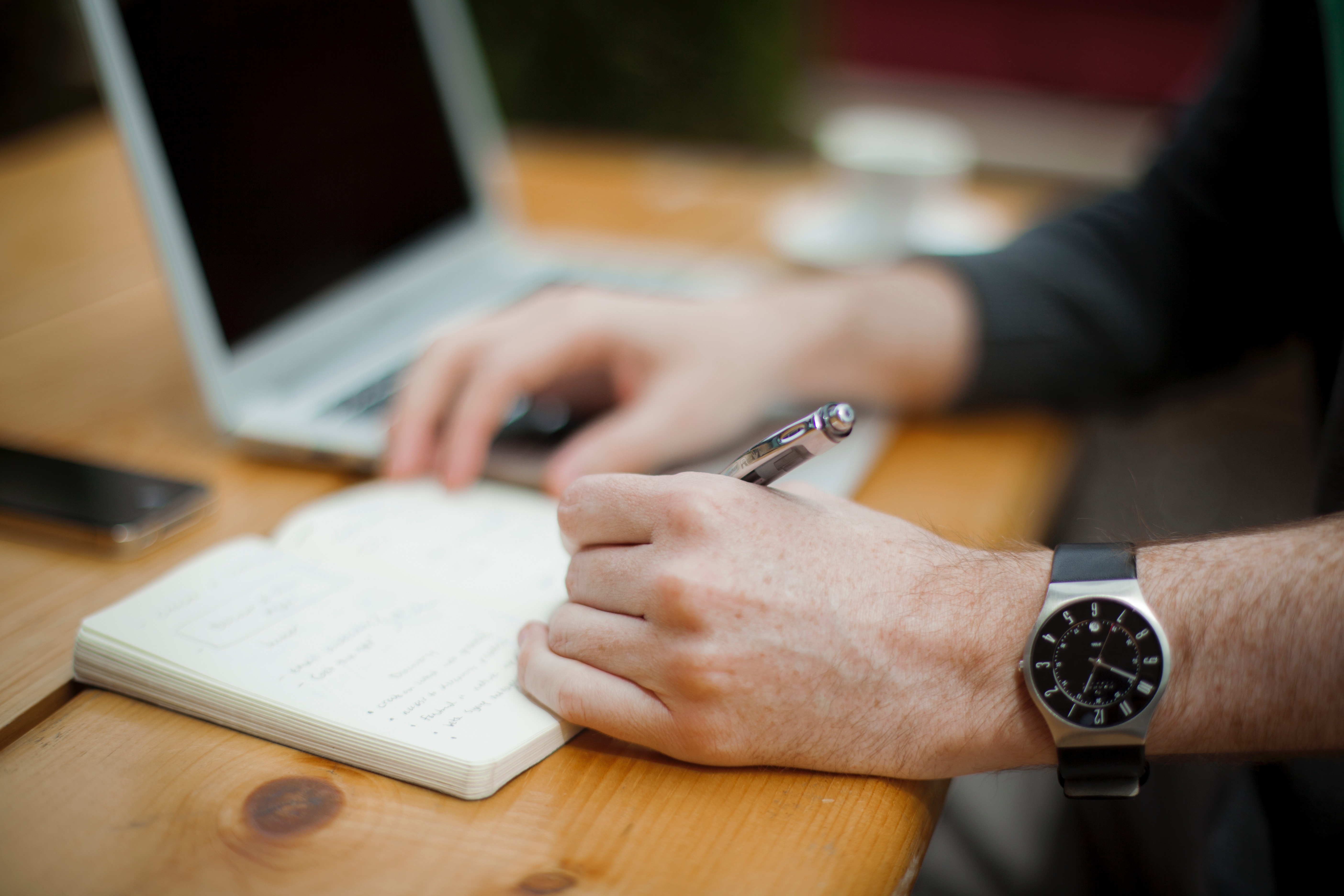 a man in sleeves writing in a planner and choosing from the productivity apps option