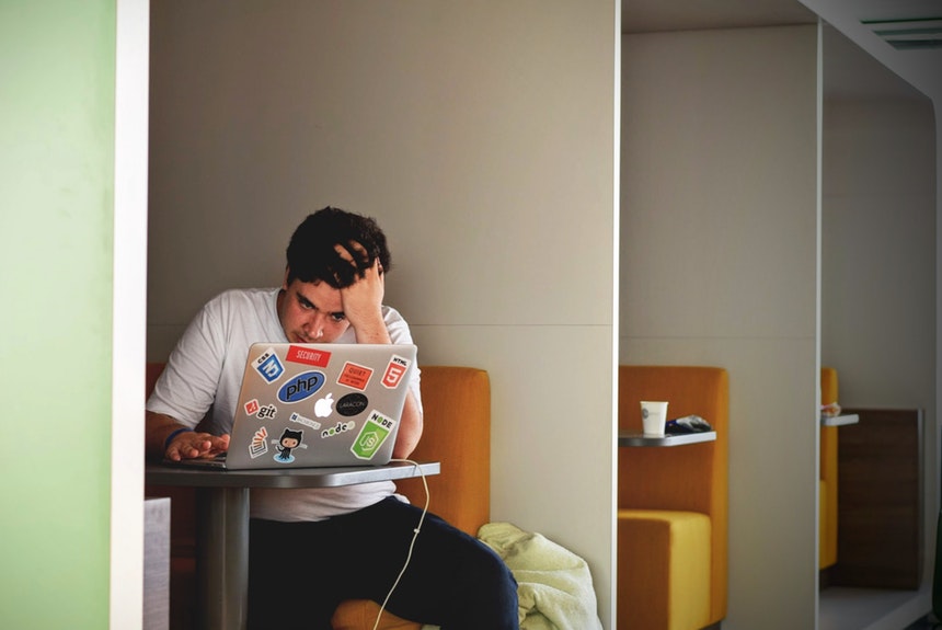 annoyed man due to horrible resume mistakes in front of a laptop