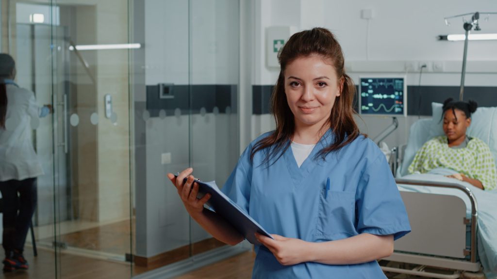 A medical assistant holding a document standing