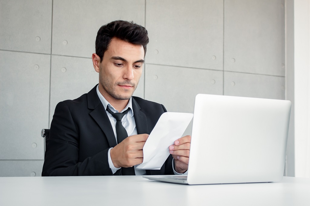 A man writing two week notice holding a document