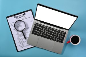 Top view of a laptop and a magnifying glass highlighting the computer skills on resume