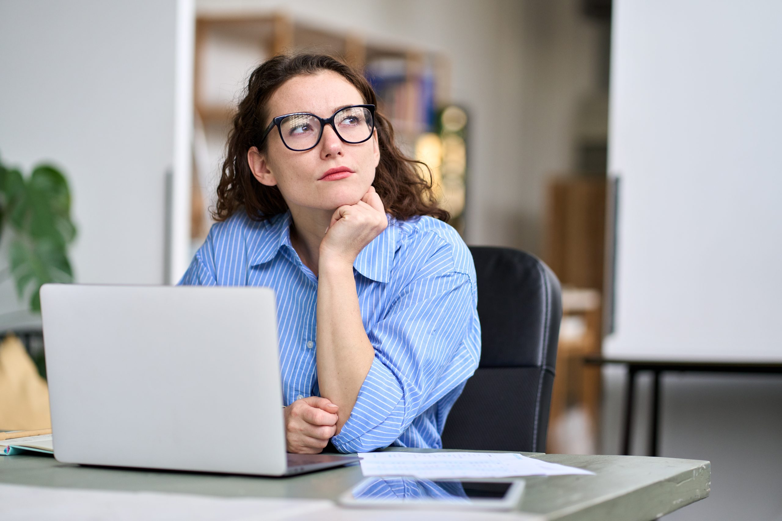 Thoughtful serious professional woman writing email
