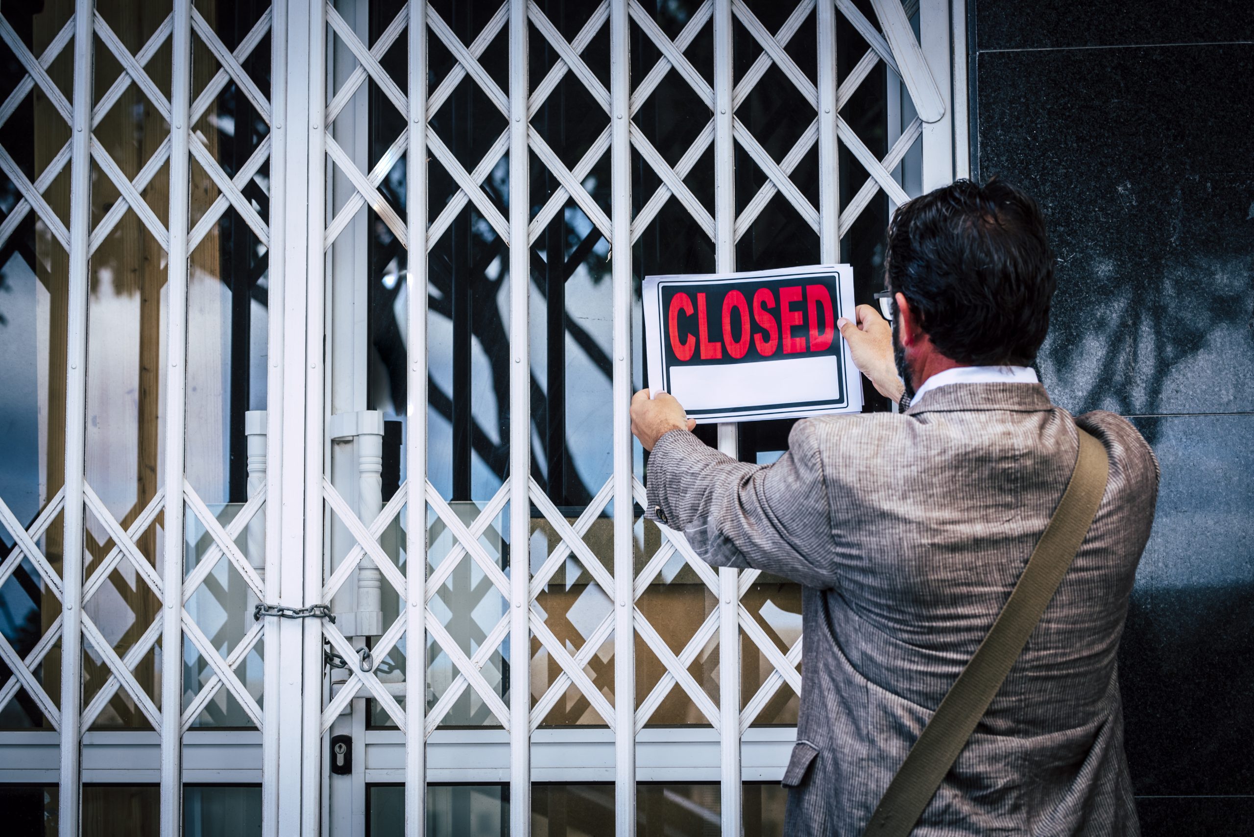 businessman closing his business as a sign of layoff 