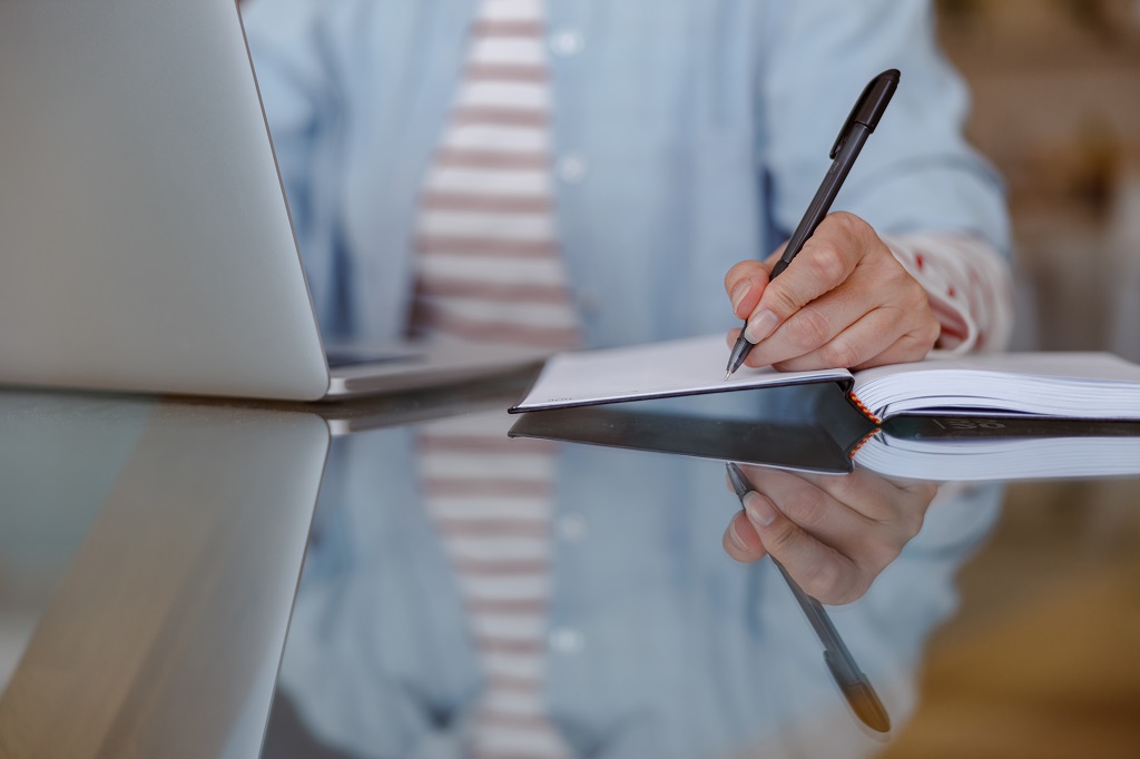 job applicant taking notes on how to write a strategic salary negotiation email