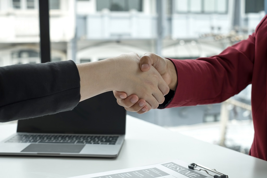 employer and applicant shaking hands after a successful job interview